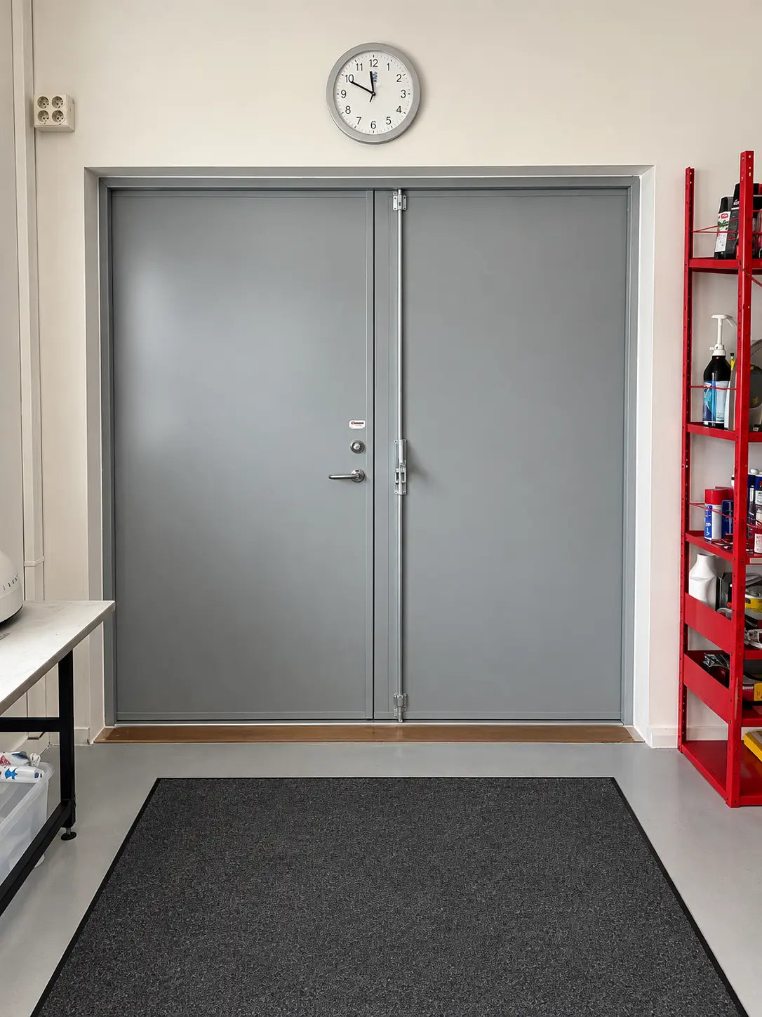 Grå stålpardörr installerad i en teknisk inomhusmiljö